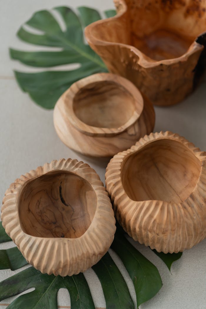 Mastering the First Impression: Your intriguing post title goes here A collection of handcrafted wooden bowls displayed on monstera leaves, showcasing natural rustic decor.