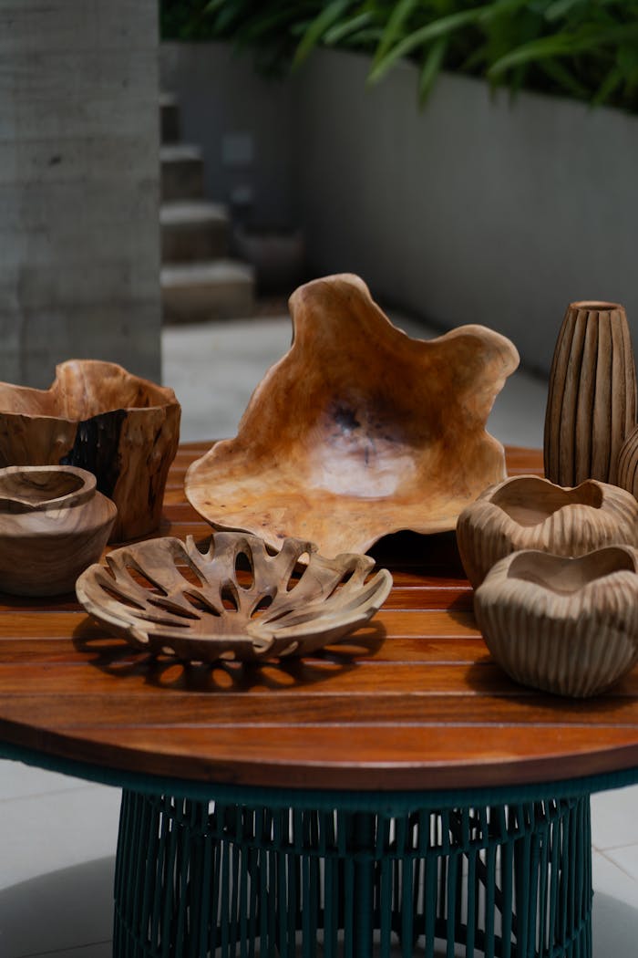 The Art of Drawing Readers In: Your attractive post title goes here A collection of carved wooden decorative bowls and vases on an outdoor table.